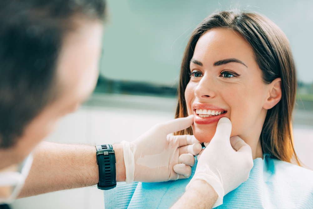 A dentist examining a smiling woman's teeth in a dental clinic - Dentist Graham WA A dentist examining a smiling woman's teeth in a dental clinic - Dentist Graham WA